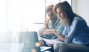 Zwei Personen vor Laptop